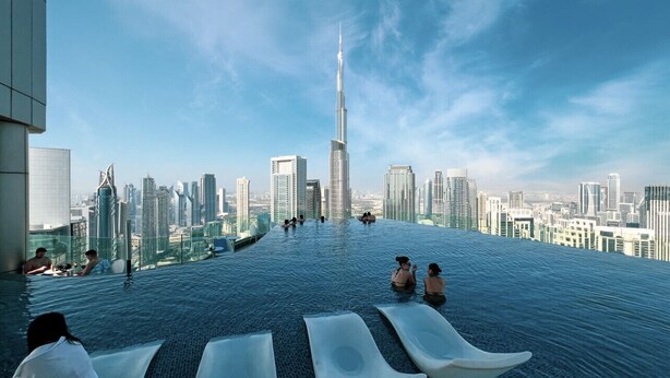 An infinity pool with a city skyline view, including a prominent skyscraper. - 2BR |Sea & City Views |Infinity Pool |High Floor (Dubai)