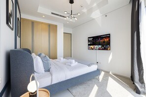 A modern hotel room with a bed, a TV mounted on the wall, and a large window. - 2BR |Sea & City Views |Infinity Pool |High Floor (Dubai)