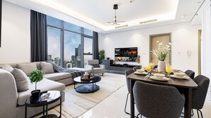 A modern living room with a sofa, coffee table, dining table, and chairs. - 2BR |Sea & City Views |Infinity Pool |High Floor (Dubai)