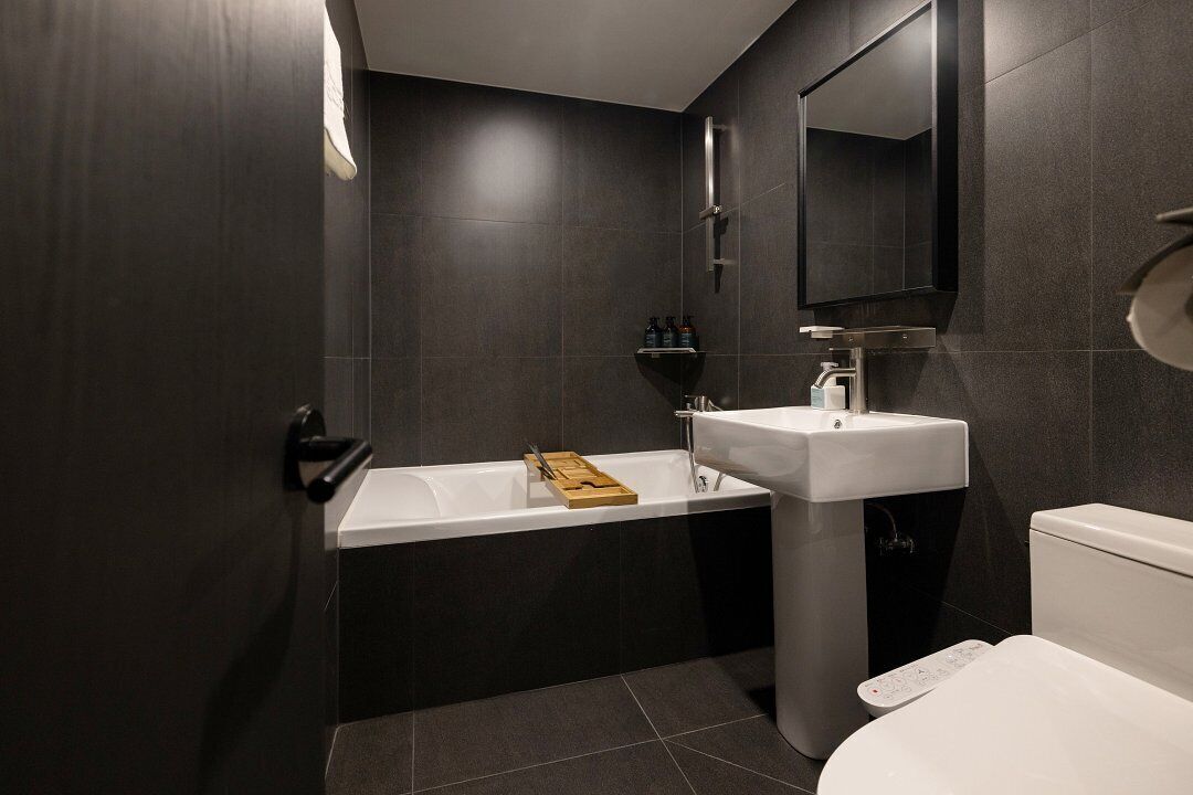A modern bathroom with a bathtub, sink, and toilet.