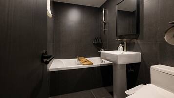 A modern bathroom with a bathtub, sink, and toilet.