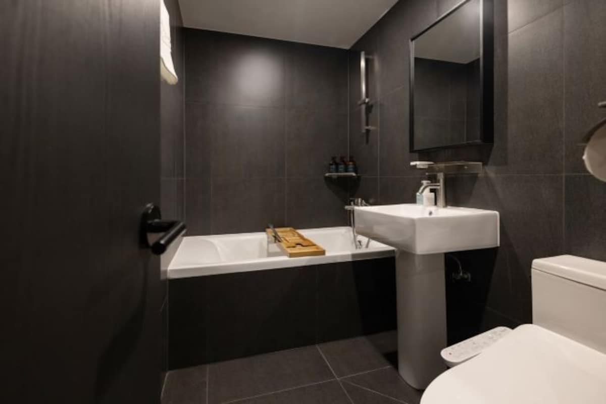 A modern bathroom with a bathtub, a sink, and a toilet.