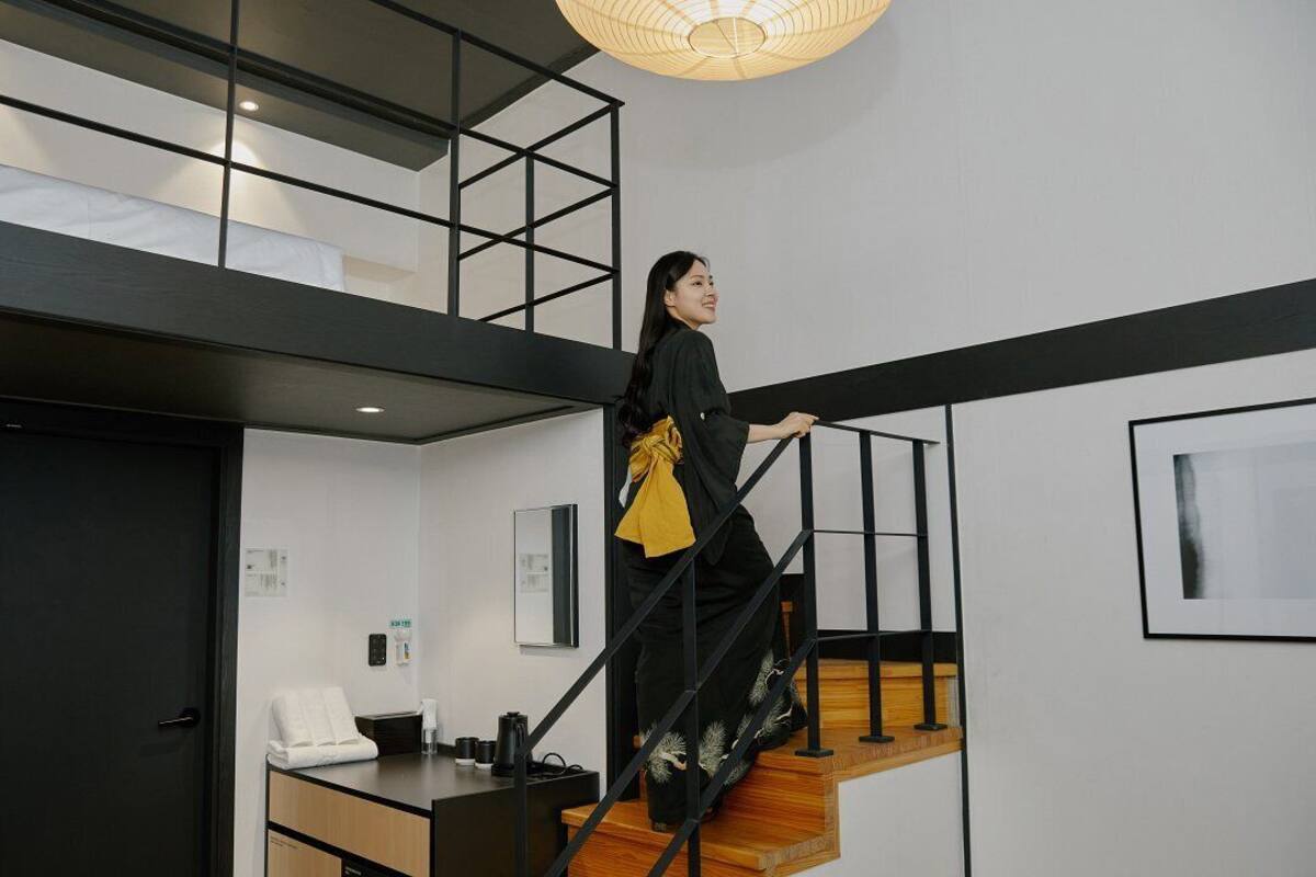 A modern interior with a staircase, a desk with a phone, and a framed picture on the wall.