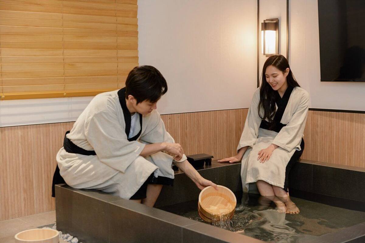 A traditional Japanese onsen with wooden benches and a stone basin.