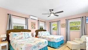 A bedroom with two beds, a ceiling fan, and a window with curtains. - easy access to beach, large family retreat, huge outdoor area (Treasure Island)