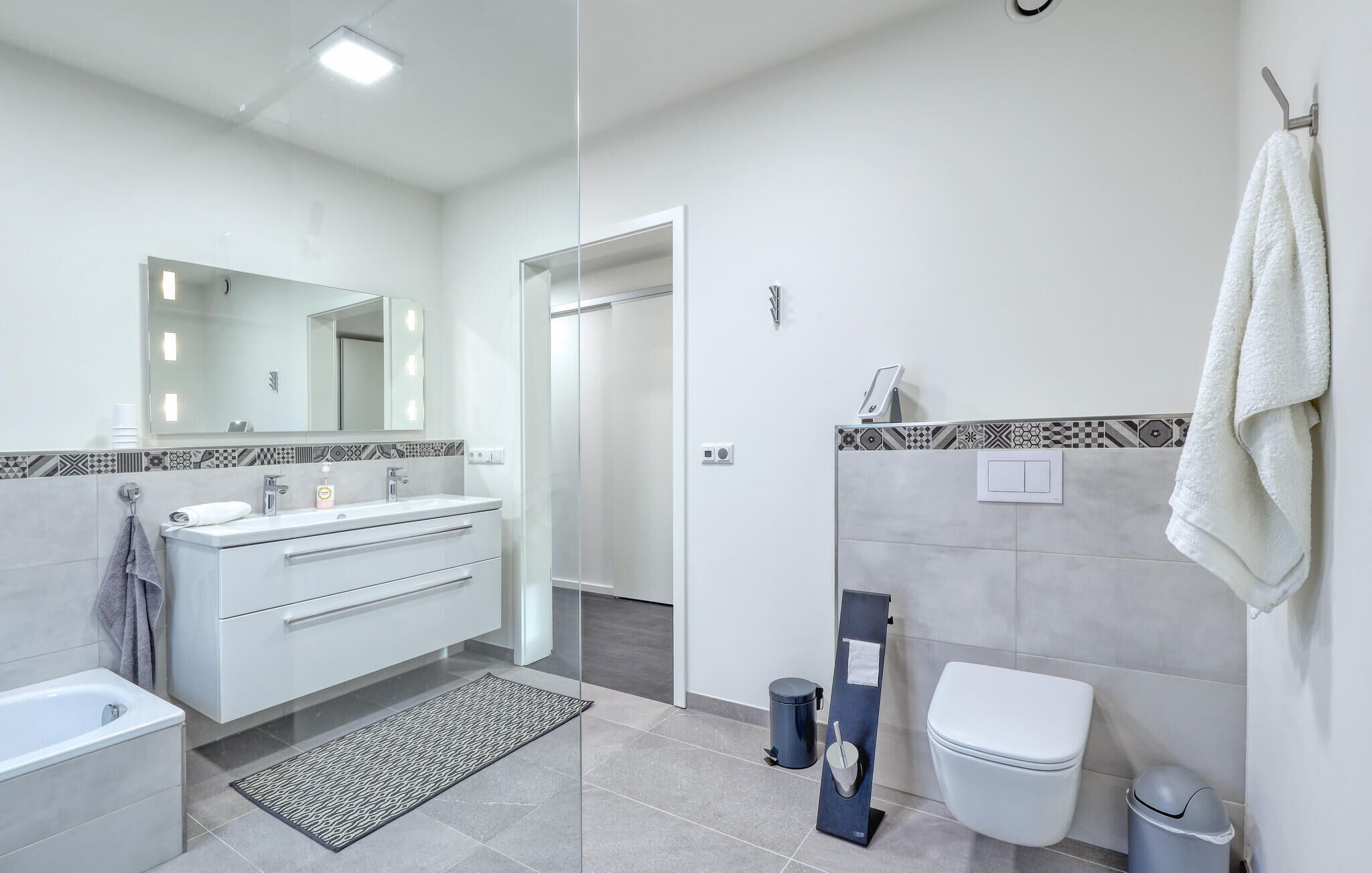 Une salle de bain moderne avec un meuble-lavabo, un évier, un miroir et des toilettes.