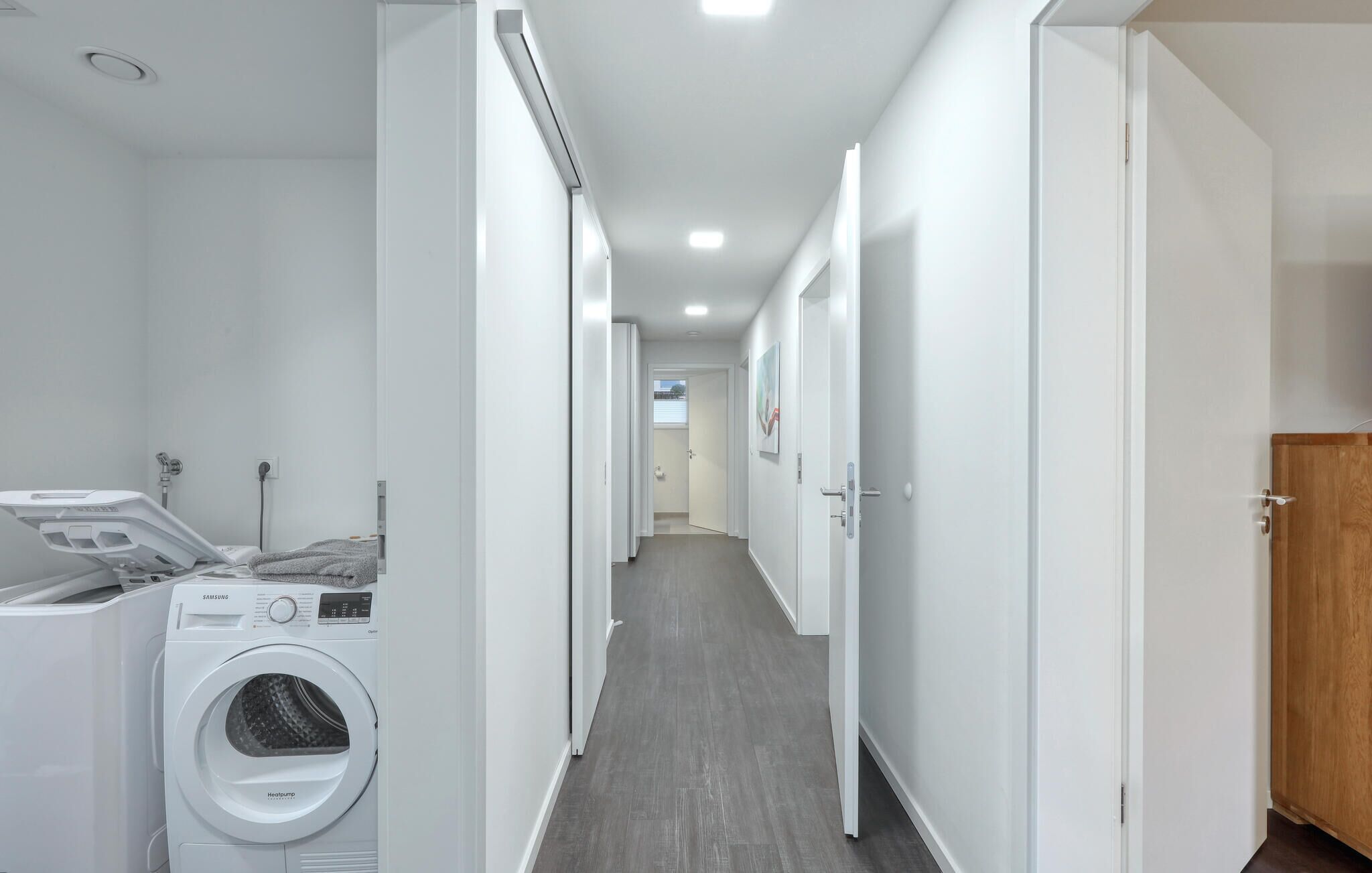 A laundry room with a Samsung heat pump washer, a drying machine, and a shower.