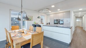 A modern kitchen with white cabinets, a central island, and stainless steel appliances. - 2 bedroom nice apartment in Eckernförde (Eckernförde)
