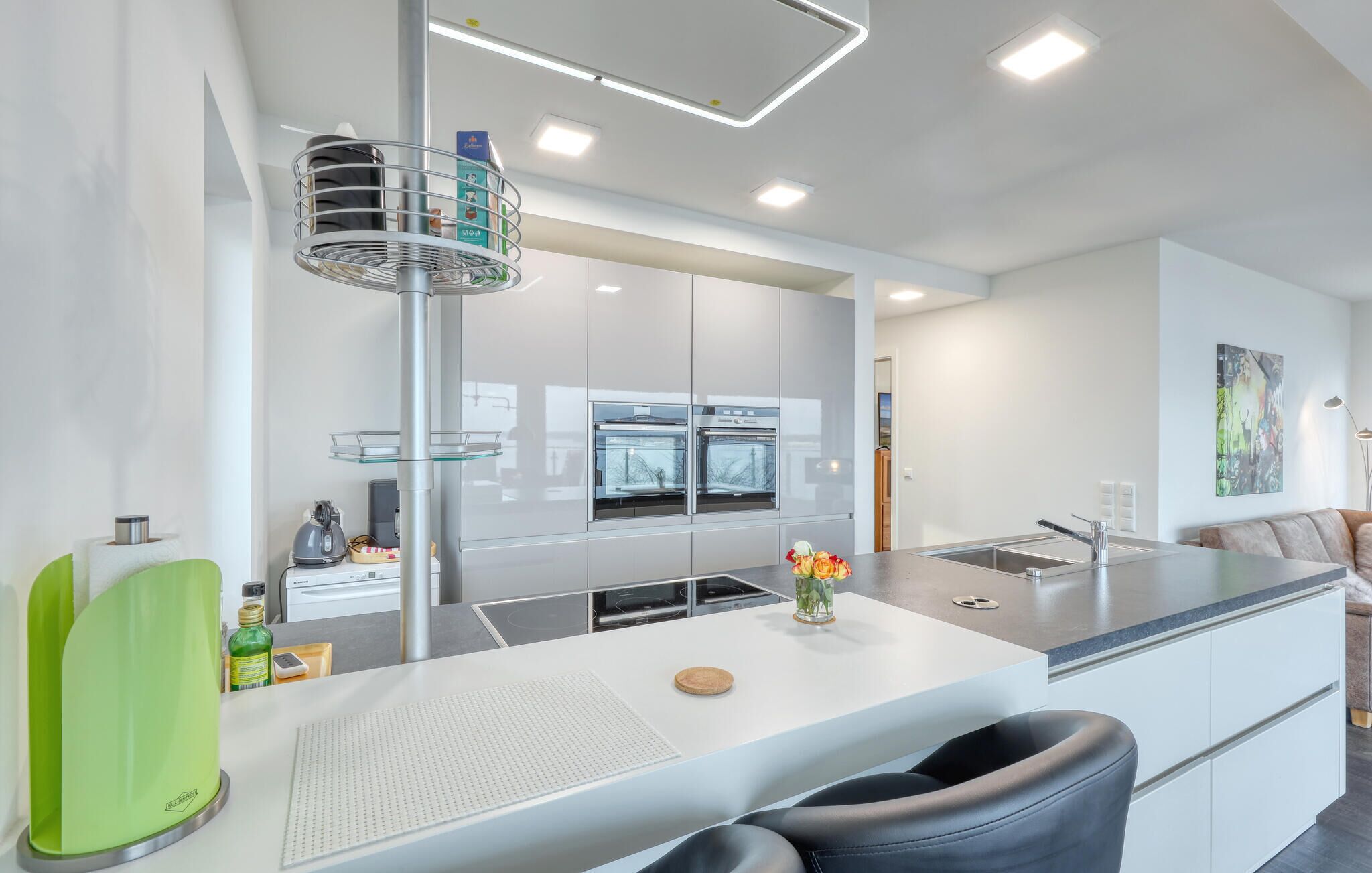 A modern kitchen with white cabinetry, stainless steel appliances, and a central island.