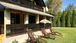 A house with a balcony, a satellite dish, and a lawn with lounge chairs. - Stunning private villa for 8 people with WIFI, TV, patio and pets allowed (Marcali)