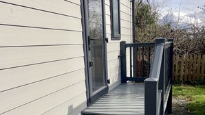 Un edificio moderno con fachada de madera, un juego de escaleras exteriores y una valla de madera al fondo.