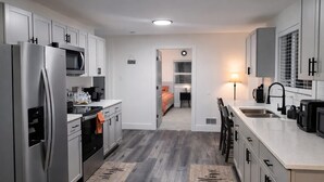 Une cuisine moderne dotée d’appareils électroménagers en acier inoxydable, de meubles de couleur grise et d’un îlot central.