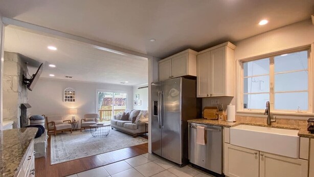 A modern kitchen with a refrigerator, sink, and cabinets.