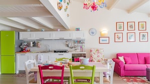 A bright kitchen with white cabinets, a green refrigerator, and a dining area with a table and chairs. - 2 bedroom nice apartment in Donnalucata (Donnalucata)