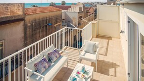 A balcony with white furniture, a table with decorative items, and a view of the sea. - 2 bedroom nice apartment in Donnalucata (Donnalucata)