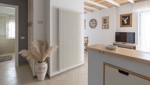 Eine moderne Küche mit einer Holzausziehtheke, einem Heizkörper und einem Fernseher.
