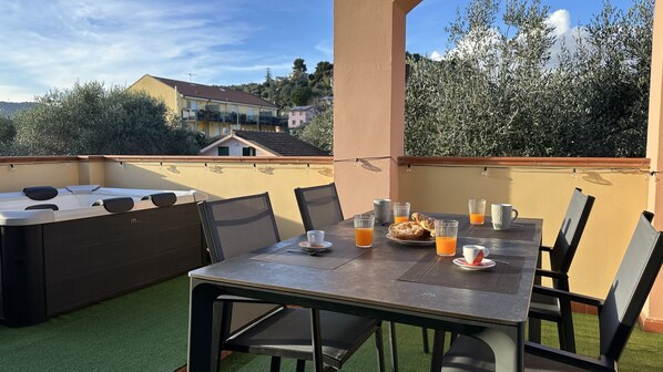 A dining area with a table set for breakfast, including croissants, orange juice, and a cup.
