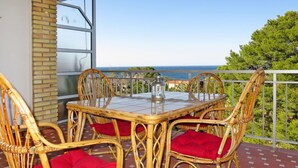 A dining area with a table and chairs on a balcony overlooking the sea. - Nice apartment for 4 people with pool, WIFI, TV and balcony (Denia)