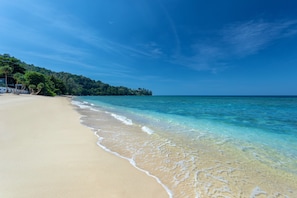 On the beach, white sand, sun-loungers, beach umbrellas