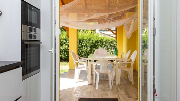 An open door leading to a patio with a table and chairs, a yellow wall, and a wooden ceiling. - Wonderful private villa for 8 guests with terrace and pets allowed (Keszthely)