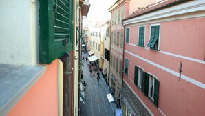 A narrow street with buildings on either side, featuring balconies and awnings. - Garibaldi 135 in Loano (Loano)