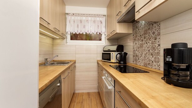 A compact kitchen with wooden cabinets, a microwave, a kettle, and a coffee machine. - Beautiful  villa for 5 guests with A/C, TV and terrace (Keszthely)