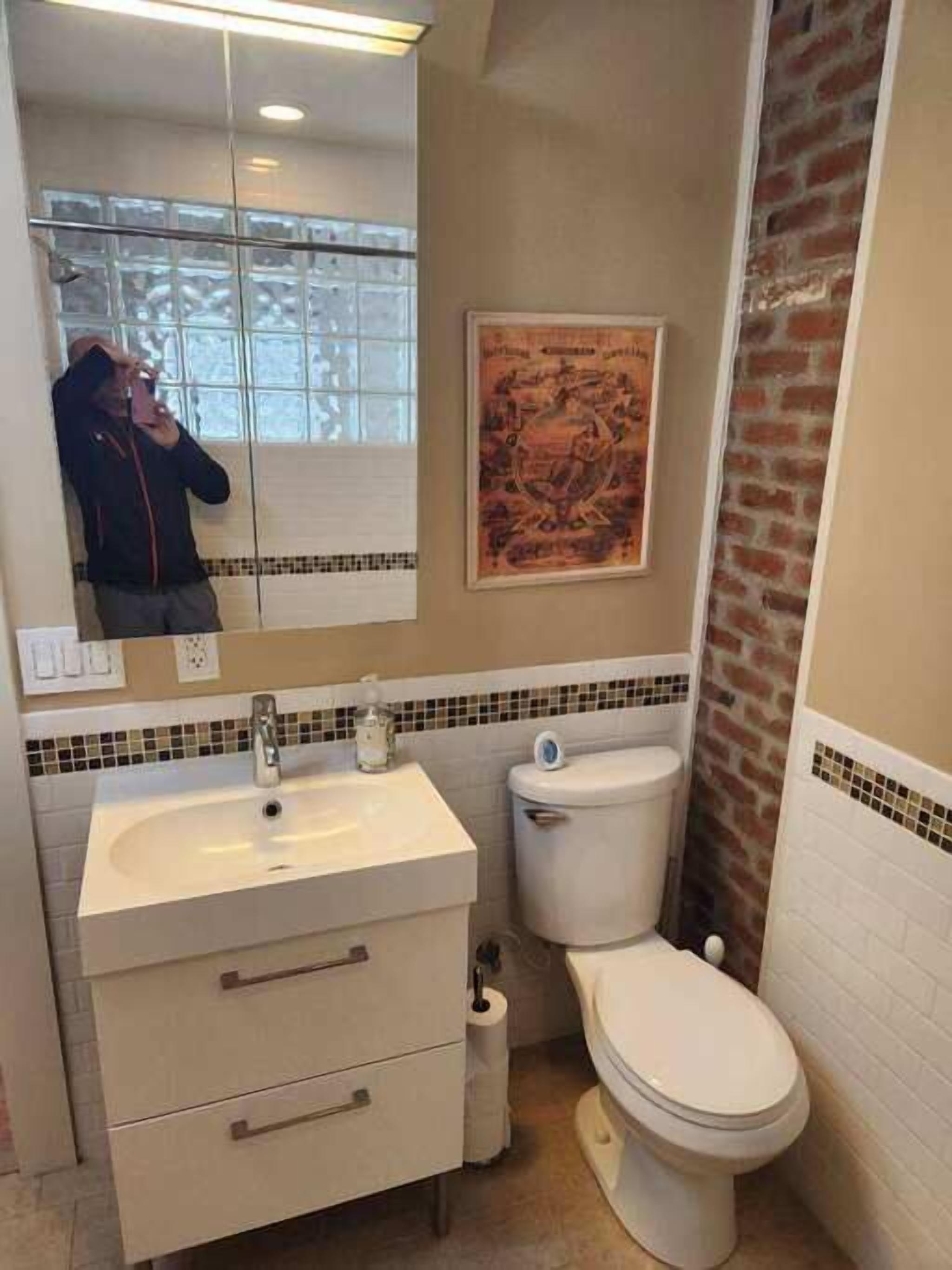 Un baño con un lavamanos blanco, un inodoro y un espejo.