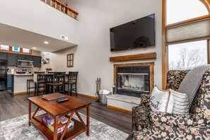 TV connectée, cheminée, table de tennis de table, livres