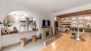 Una cocina moderna con una isla, taburetes de madera y un televisor.