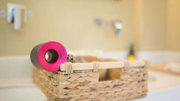 A woven basket with a pink object on a bathroom counter.