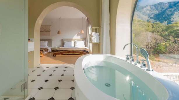 Un baño moderno con una bañera grande, una zona de ducha y vistas a las montañas.