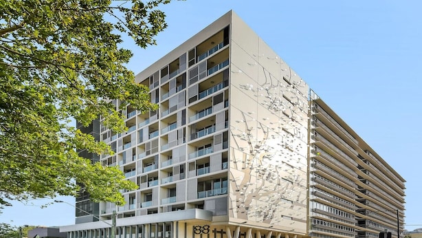 A modern multi-story building with a unique facade design, featuring a series of balconies and a prominent entrance with a glass canopy. - lovely ap in  heart of chatswood (Chatswood)