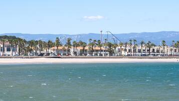 A coastal resort with beach access, palm trees, and a clear view of the sea.