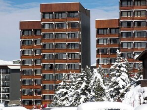 Un hôtel à plusieurs étages au design moderne, doté de nombreux balcons et de grandes fenêtres.