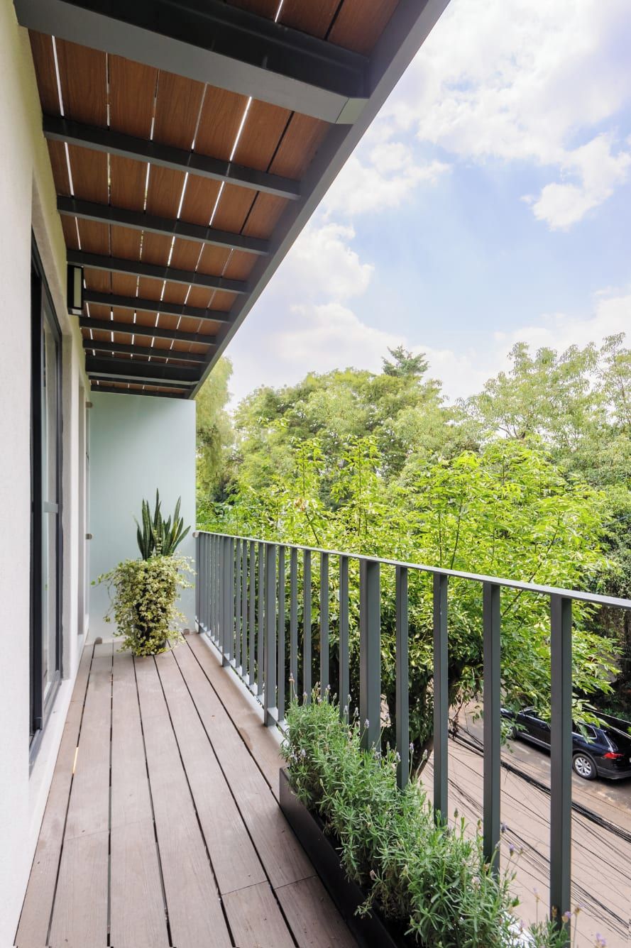 Ein Holzbalkon mit Blick auf Bäume und eine Straße.