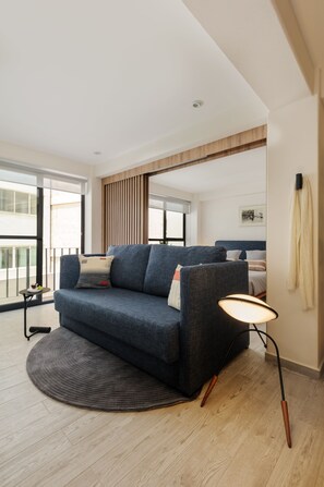 A modern living room with a sofa, a round rug, and a floor lamp. - Brand New Modern Apartment in Condesa (Ciudad de México)