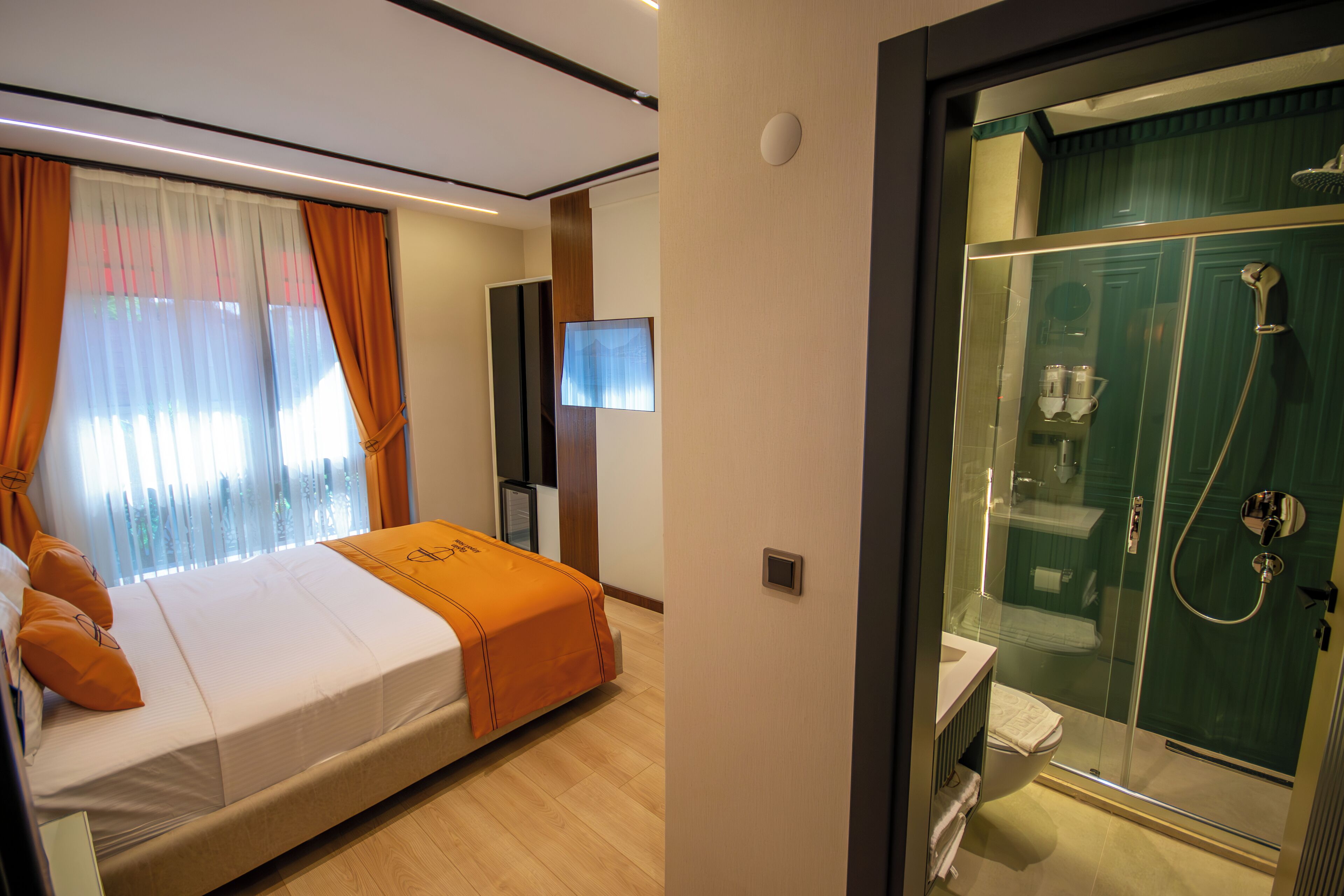 Ein Hotelzimmer mit Bett, Fernseher, Dusche und Bad.