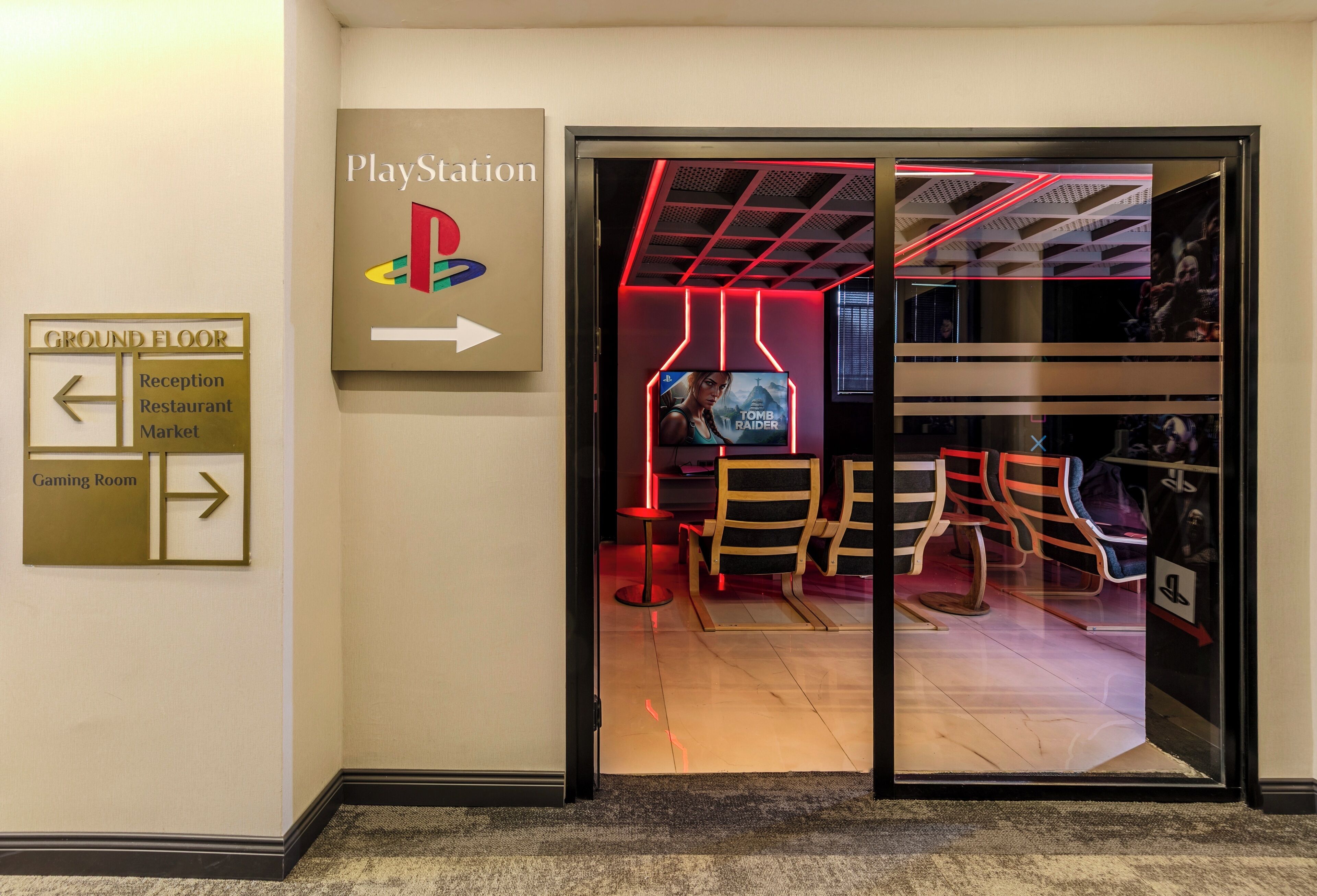 L’entrée du magasin PlayStation est signalisée par des panneaux indiquant la direction à suivre pour accéder au rez-de-chaussée, à la réception, au restaurant, au marché et à la salle de jeux.