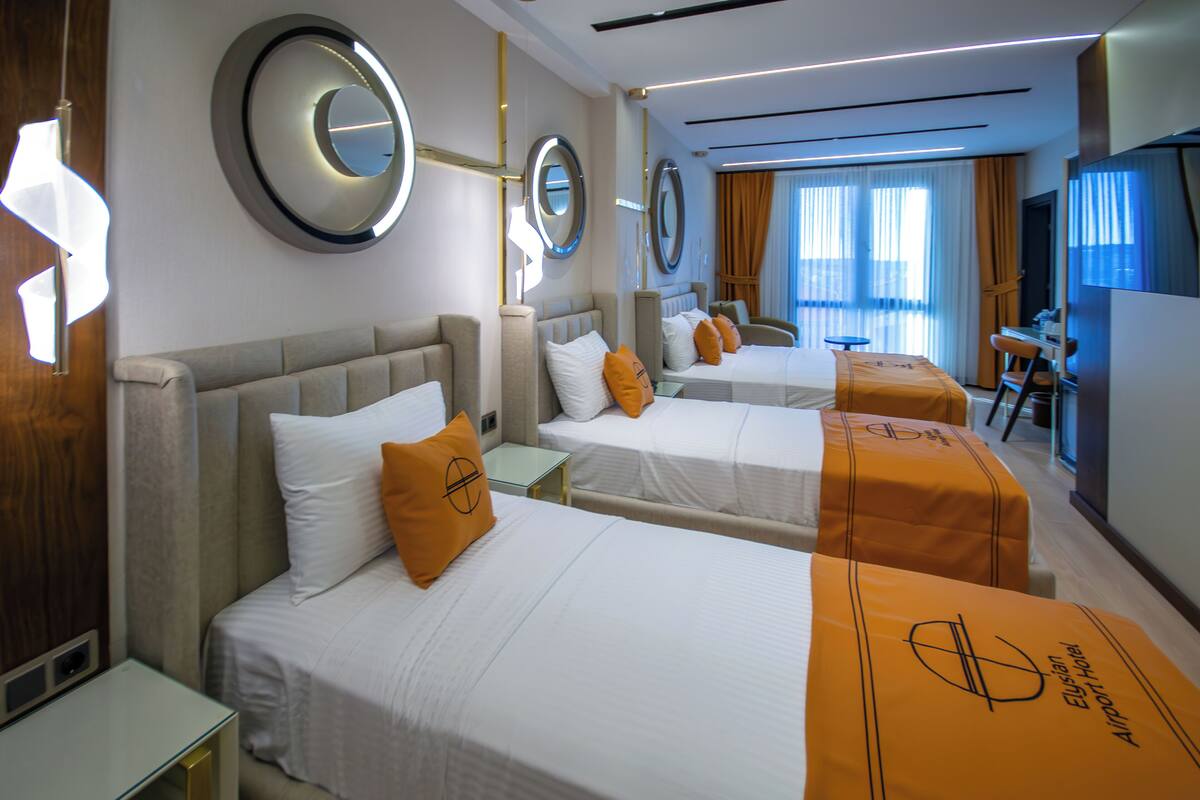Una habitación de hotel con dos camas, un escritorio y una televisión.