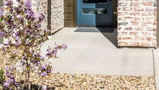 A building entrance with a blue door, numbered 51, and two wall-mounted lanterns.