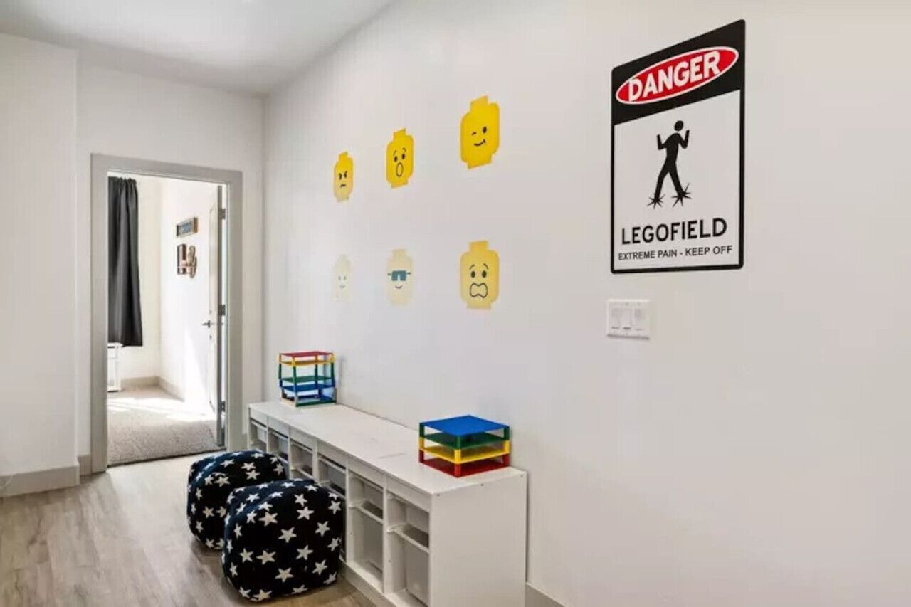 A room with a white wall, a door, and a sign that reads "DANGER LEGOFIELD EXTREME PAIN - KEEP OFF".