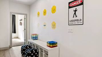 A room with a white wall, a door, and a sign that reads "DANGER LEGOFIELD EXTREME PAIN - KEEP OFF".