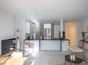 A modern apartment with a kitchen, living room, and dining area.