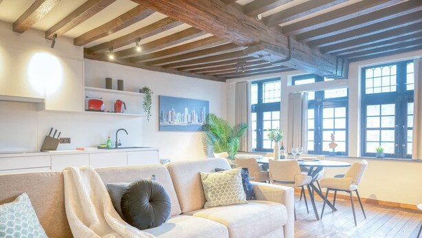 Un salon moderne comprenant un canapé, un coin repas et une cuisine.