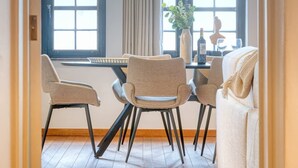 Un coin repas avec une table et quatre chaises, un vase avec des fleurs et un canapé.