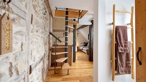 A wooden spiral staircase with a sign reading 'SERVICES' and a towel rack with towels. - Apartment 'Stub'n Balbine' with Shared Terrace and Wi-Fi (Waischenfeld)