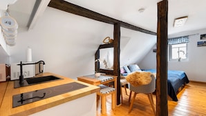 A compact room with a kitchenette, a bed, and a chair. - Apartment 'Stub'n Rettl' with Shared Terrace, Shared Garden and Wi-Fi (Waischenfeld)