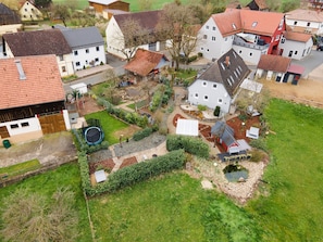 Ett flygbildsbild av ett bostadsområde med hus, en lekplats och en liten damm.