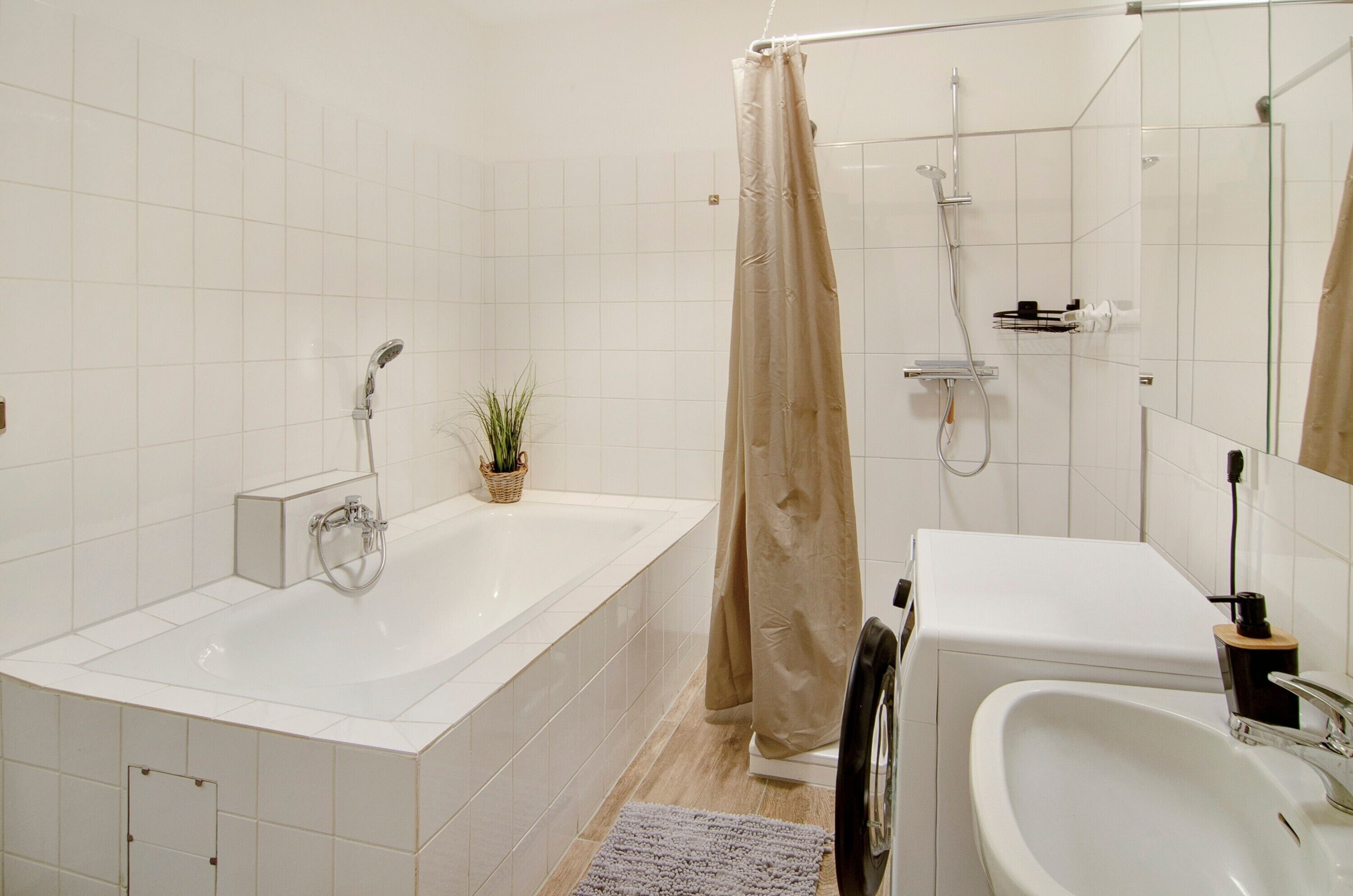 Une salle de bain avec une baignoire, une douche, un lavabo et un miroir.