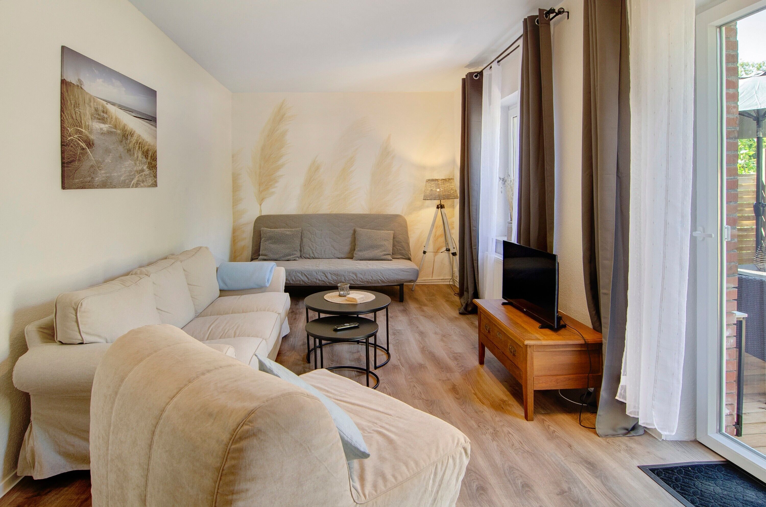 A living room with a sofa, a coffee table, a TV on a wooden stand, and a lamp.
